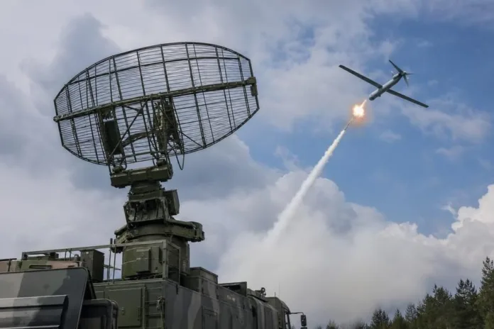 Военная радиолокационная установка направлена на летательный аппарат в небе, рядом виден след с яркой вспышкой.