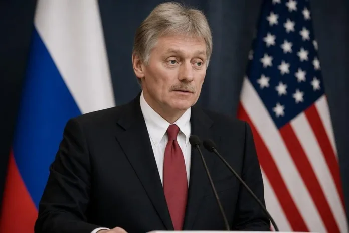 Мужчина в костюме выступает у микрофонов на фоне флагов России и США.